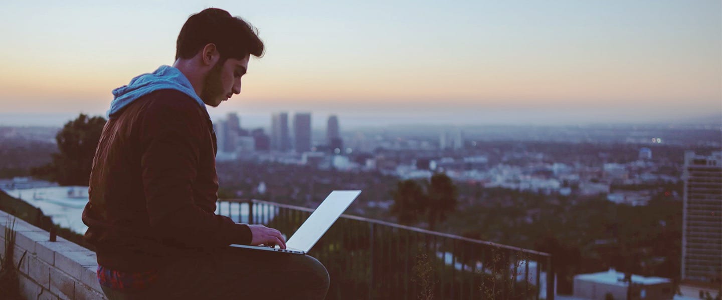 Person working on a laptop overlooking a city